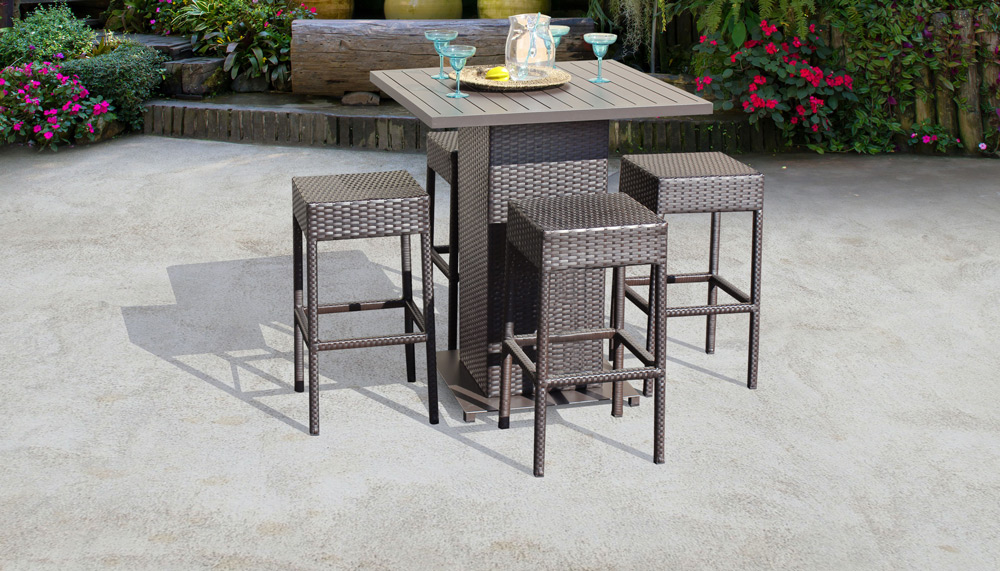 A pub style patio bar furniture set with a square high-top table and four stools.