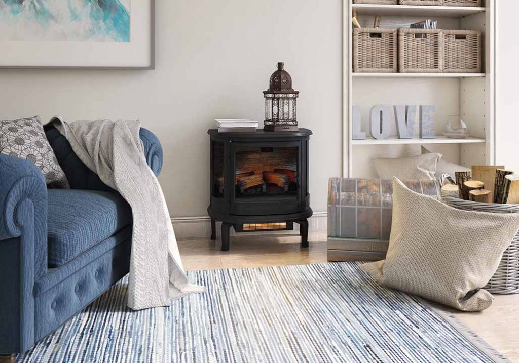 A duraflame electric stove heater with a decorative lantern on top in a room with built-in bookcases and a blue upholstered chair.