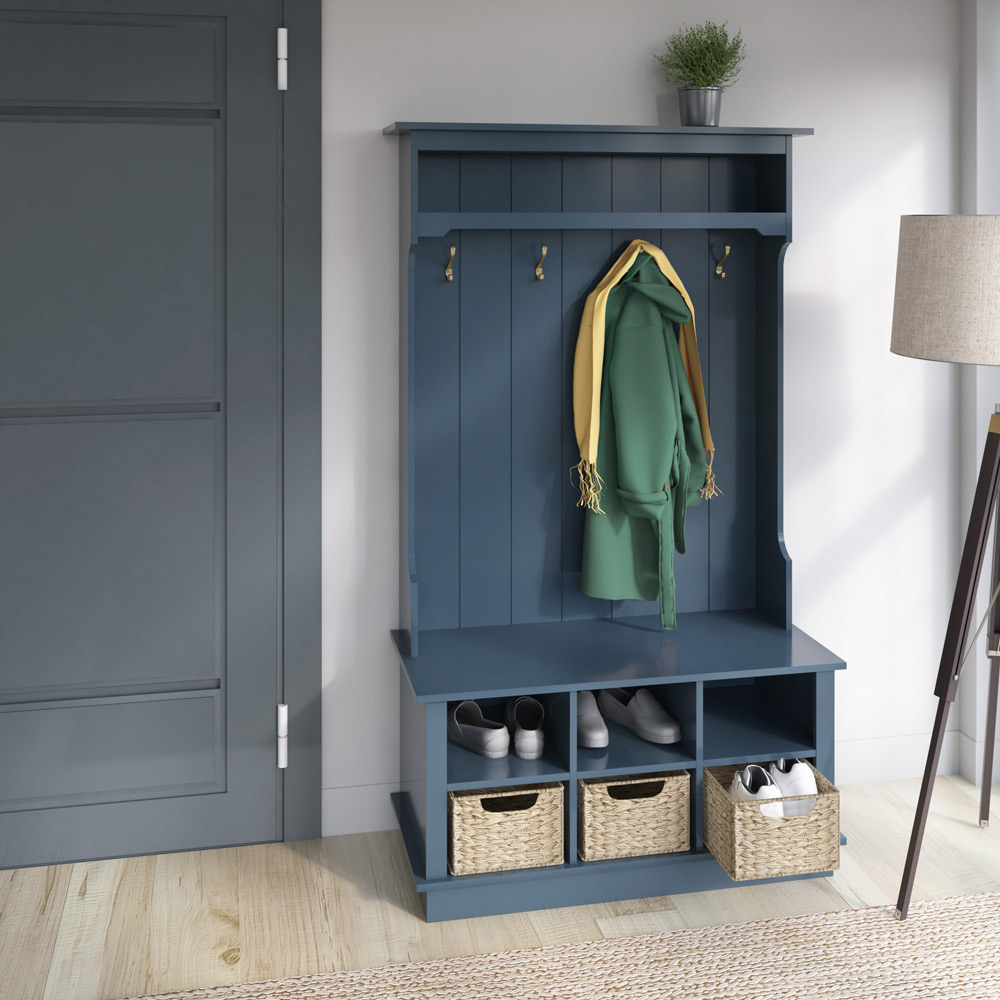 A blue hall tree with hooks above and baskets underneath the seat.